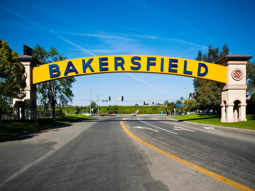 The yellow Bakersfield sign arching over a sunny street