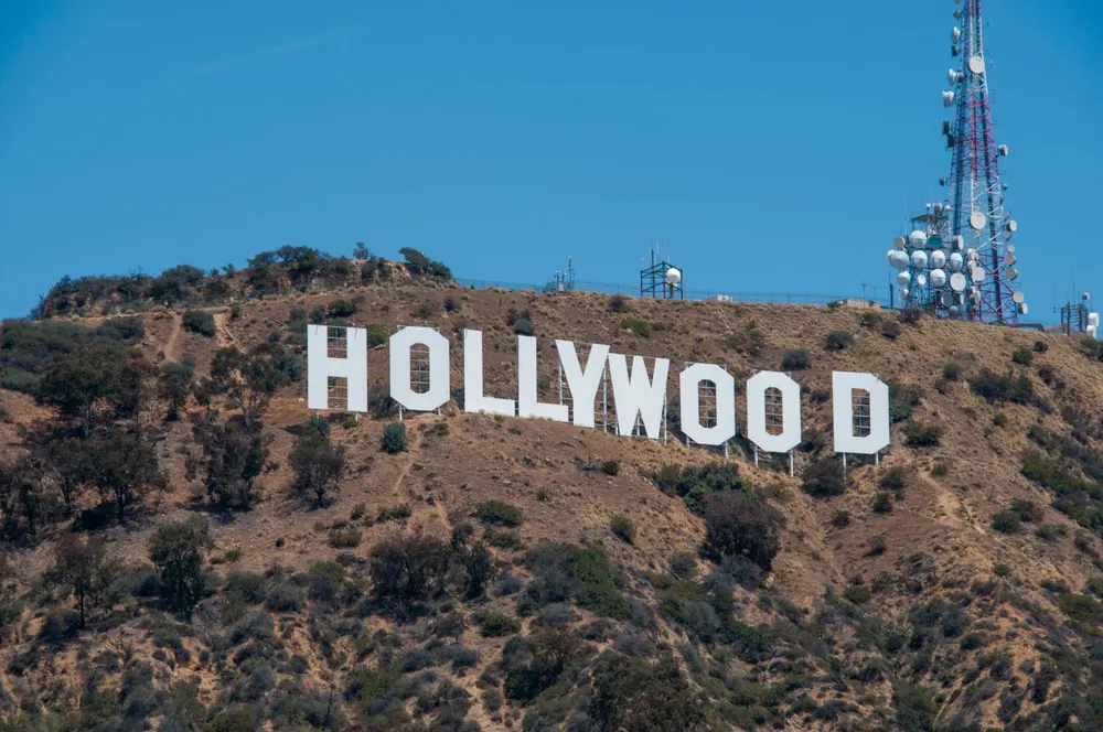 The Hollywood sign on the hills above Los Angeles under a blue sky